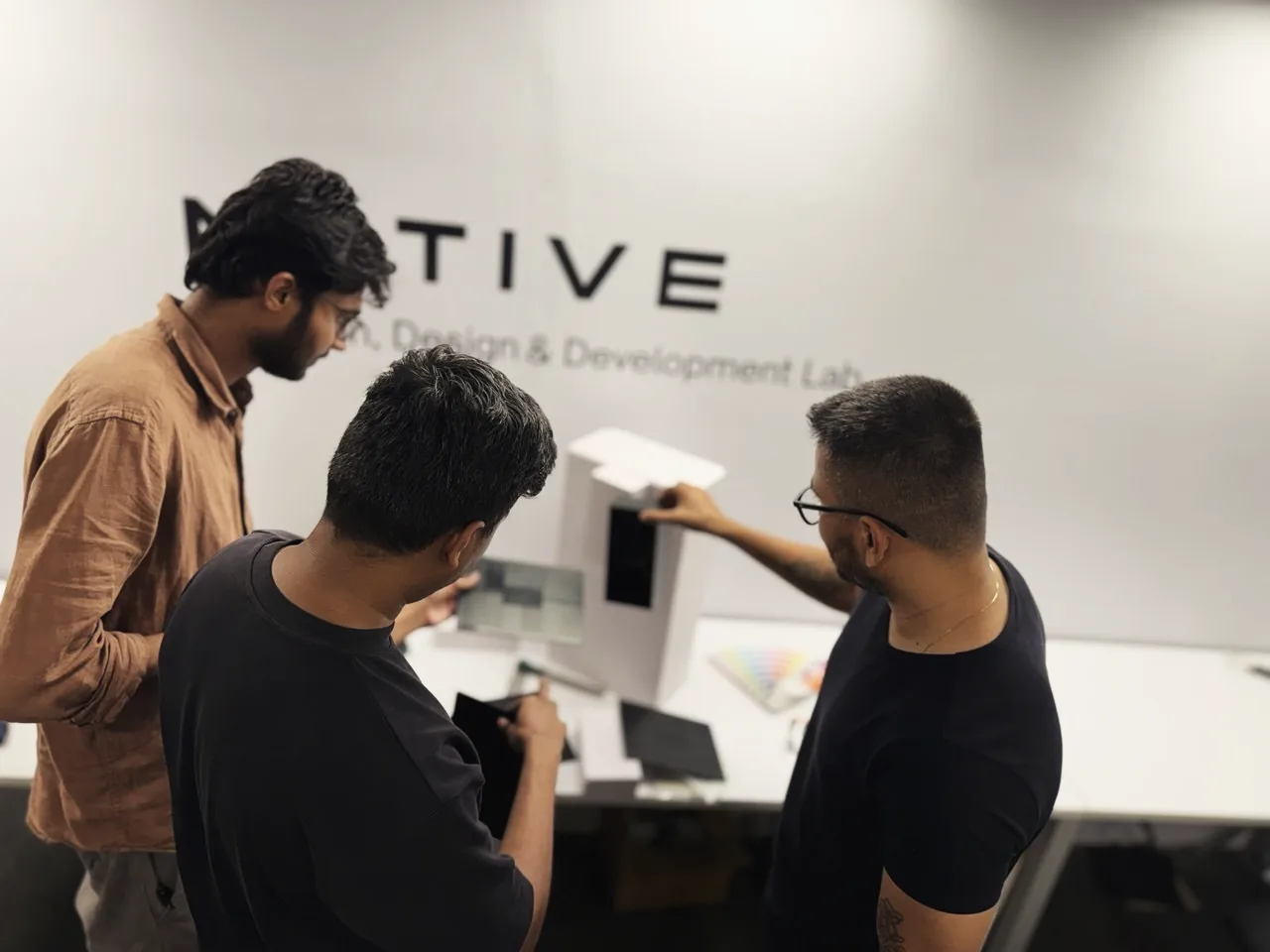 Three designers around a cardboard mock-up