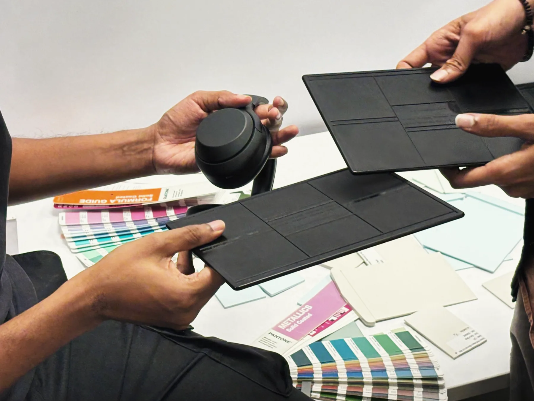 Choosing finishes: black panels held against Pantone colour guides