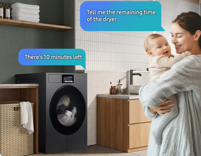 A woman holding a child in a laundry room asks Bixby the remaining time in the cycle, "Tell me the remaining time of the dryer.". Bixby replies from the dryer, "There's 10 minutes left.".